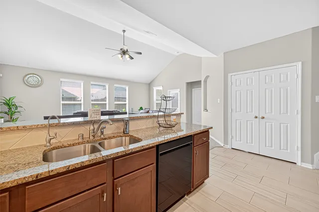 a kitchen with granite countertop wooden cabinets and a stove top oven