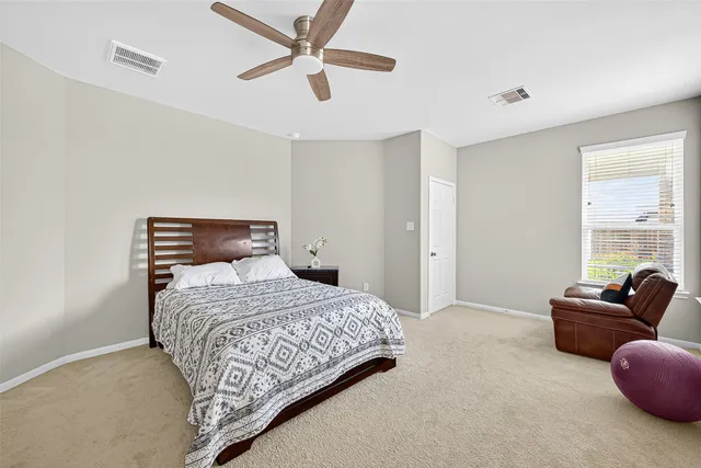 a bedroom with a bed and a ceiling fan