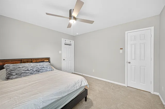 a bedroom with a bed and a chandelier fan