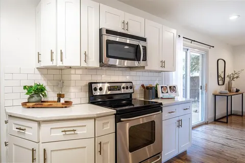 a kitchen with stainless steel appliances a stove a microwave a sink and cabinets