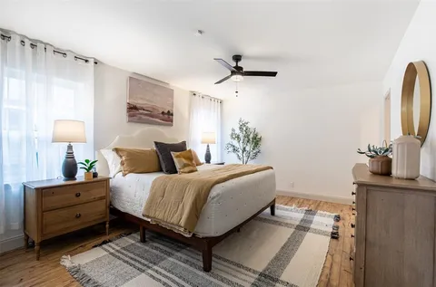 a bedroom with a bed and a flat tv screen on dresser