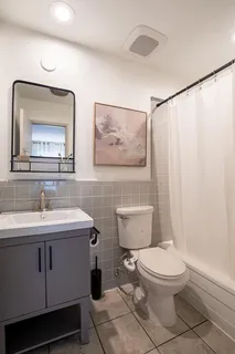 a bathroom with a toilet a sink and mirror
