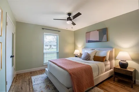 a bedroom with a bed and wooden floor