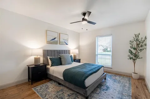 a bedroom with a large bed and a potted plant