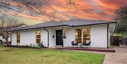 a front view of a house with a garden and plants