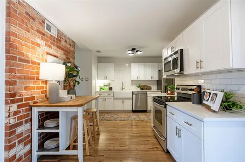 a kitchen with stainless steel appliances granite countertop a stove a sink and a microwave