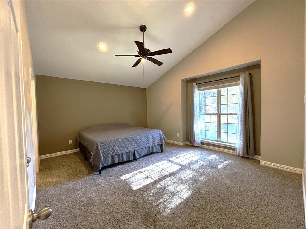 9461 Timberleaf Drive Dallas, TX 75243 - Photo 17 of 32 a spacious bedroom with a bed and a window