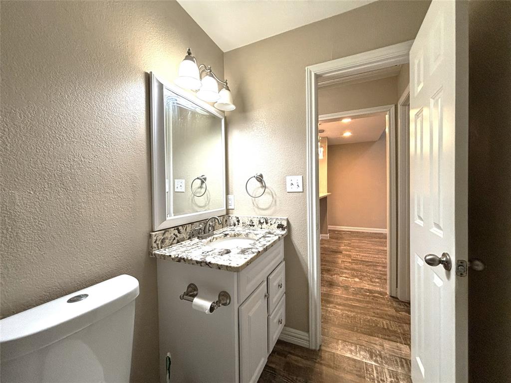 9461 Timberleaf Drive Dallas, TX 75243 - Photo 25 of 32 a bathroom with a sink a toilet and mirror