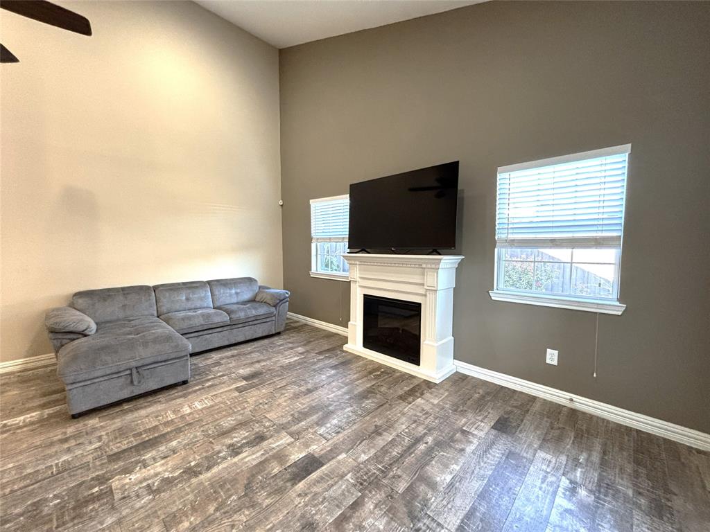 9461 Timberleaf Drive Dallas, TX 75243 - Photo 8 of 32 a living room with furniture a fireplace and a flat screen tv