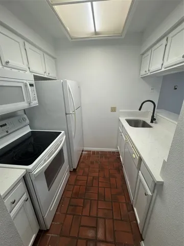 a kitchen with a sink a stove and cabinets