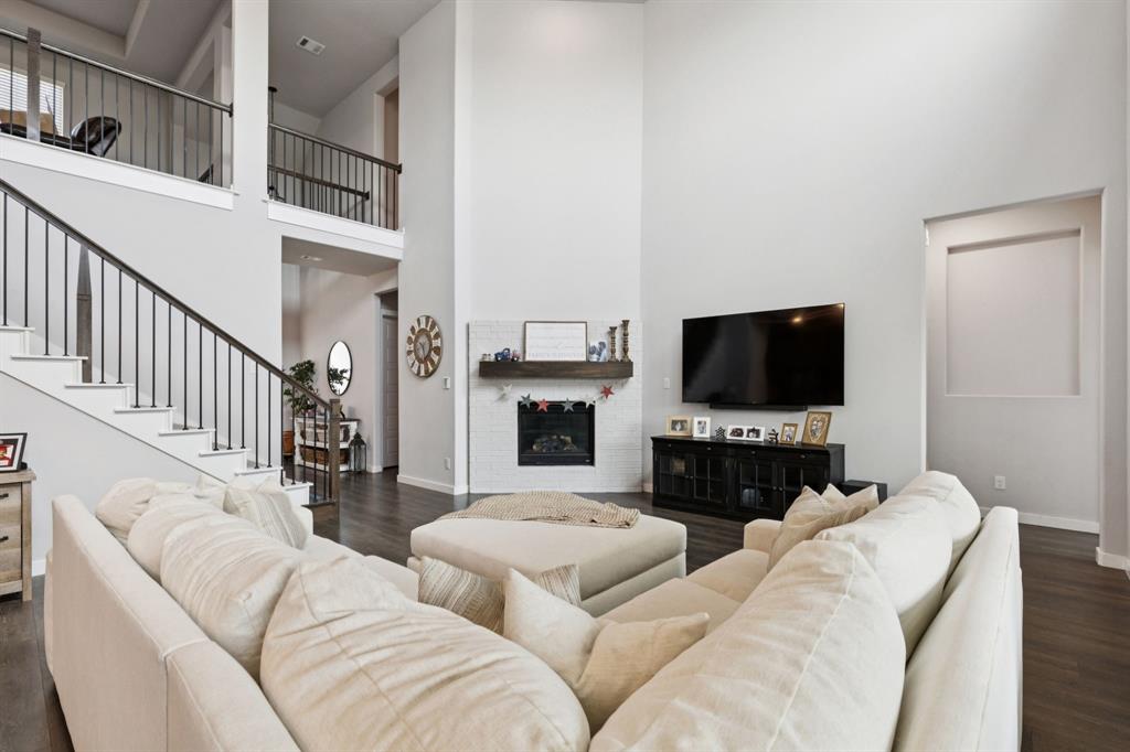 2805 Tower Road Mansfield, TX 76063 - Photo 8 of 33 a living room with furniture a flat screen tv and a fireplace