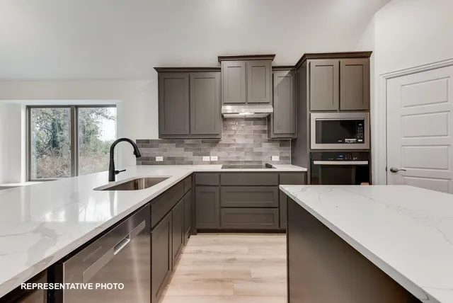 a kitchen with kitchen island granite countertop a stove top oven and sink