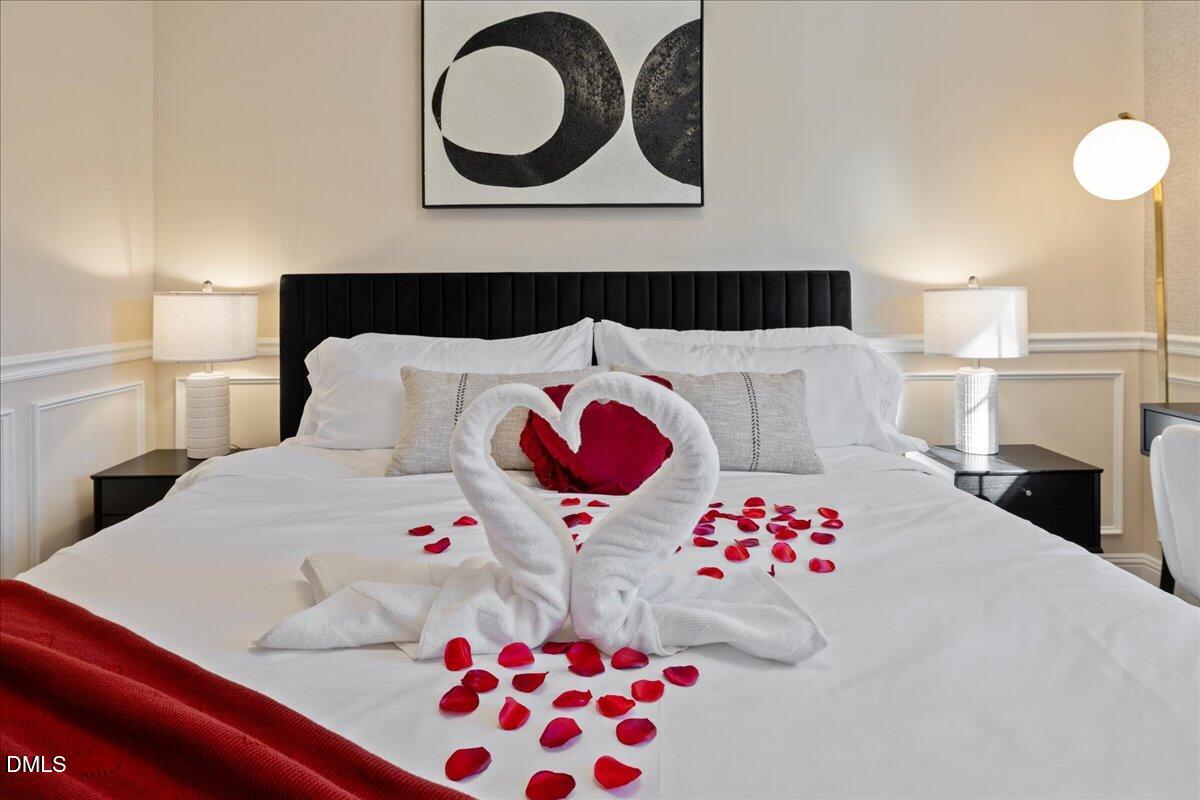 300 Pate Street Apex, NC 27502 - Photo 29 of 57 a bedroom with a bed and a chandelier