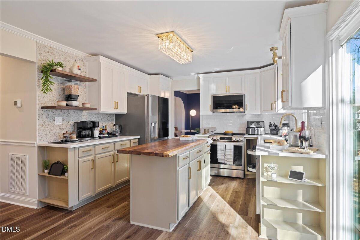 300 Pate Street Apex, NC 27502 - Photo 9 of 33 a kitchen with stainless steel appliances granite countertop a stove top oven a refrigerator a sink and dishwasher with wooden floor