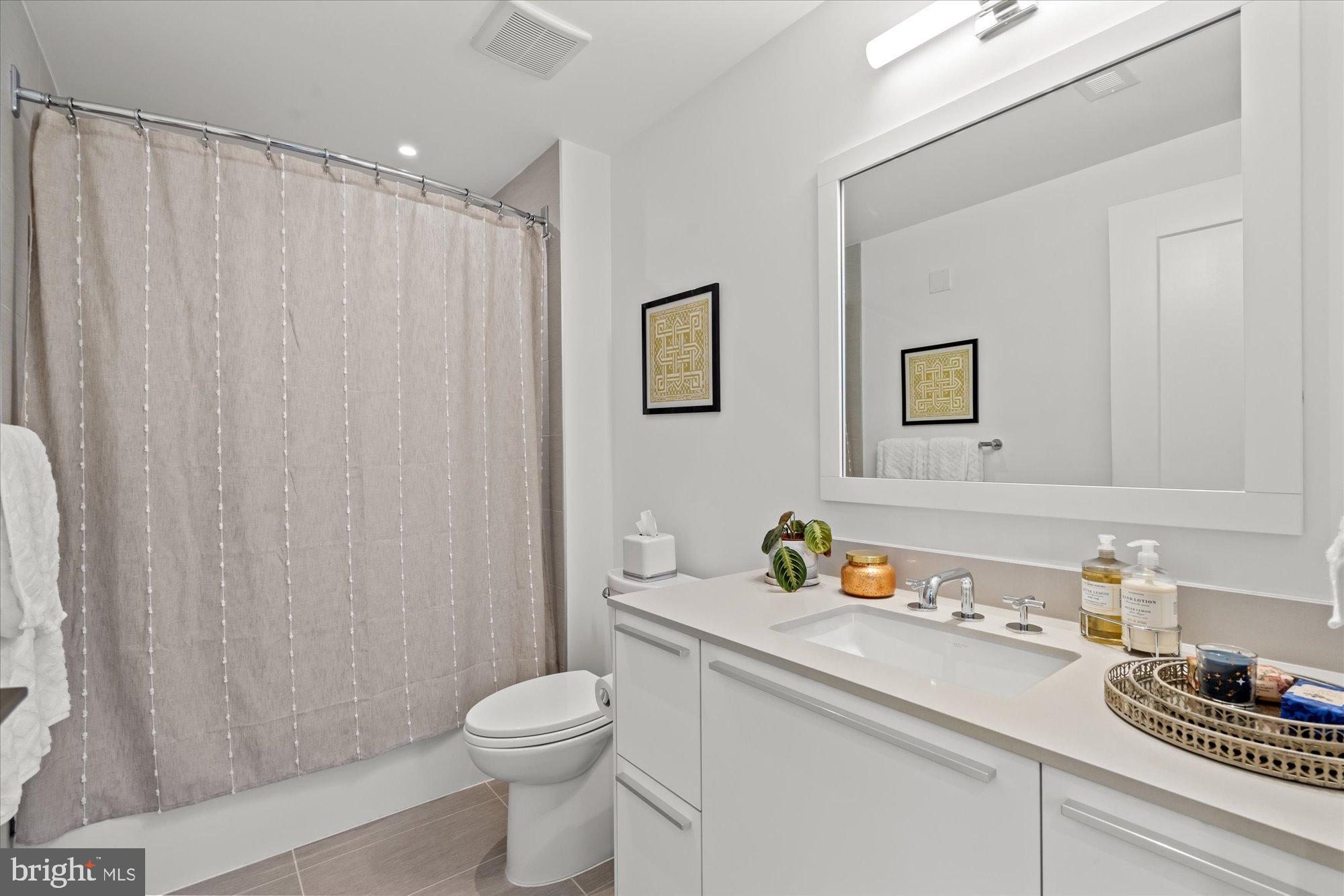 1201 North Royal Street, Unit 214 Alexandria, VA 22314 - Photo 14 of 71 a bathroom with a sink a toilet and shower curtain