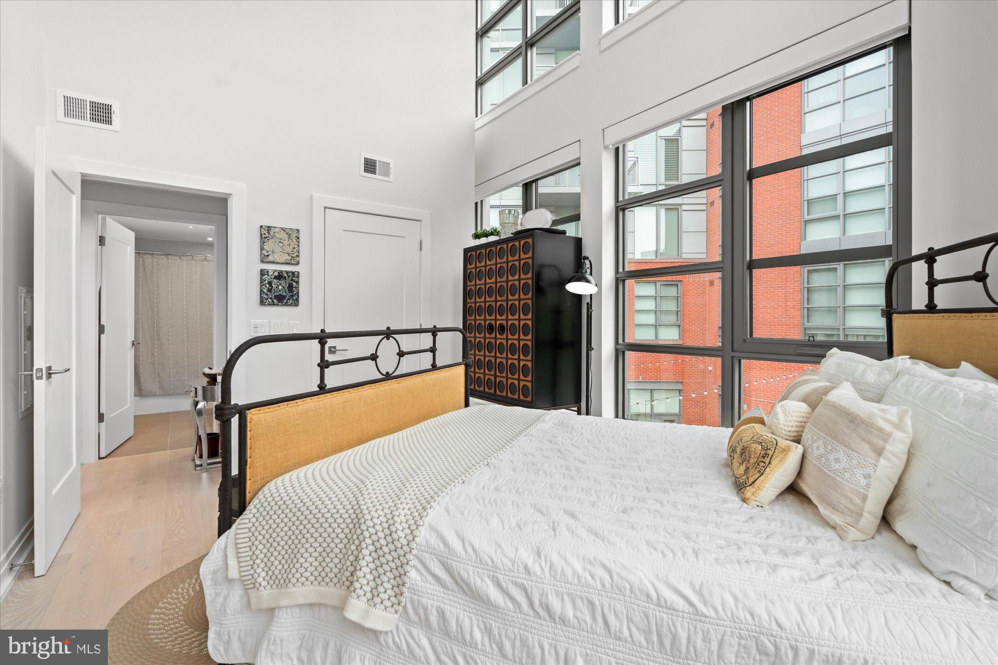 1201 North Royal Street, Unit 214 Alexandria, VA 22314 - Photo 17 of 71 a bedroom with a large bed and a chair