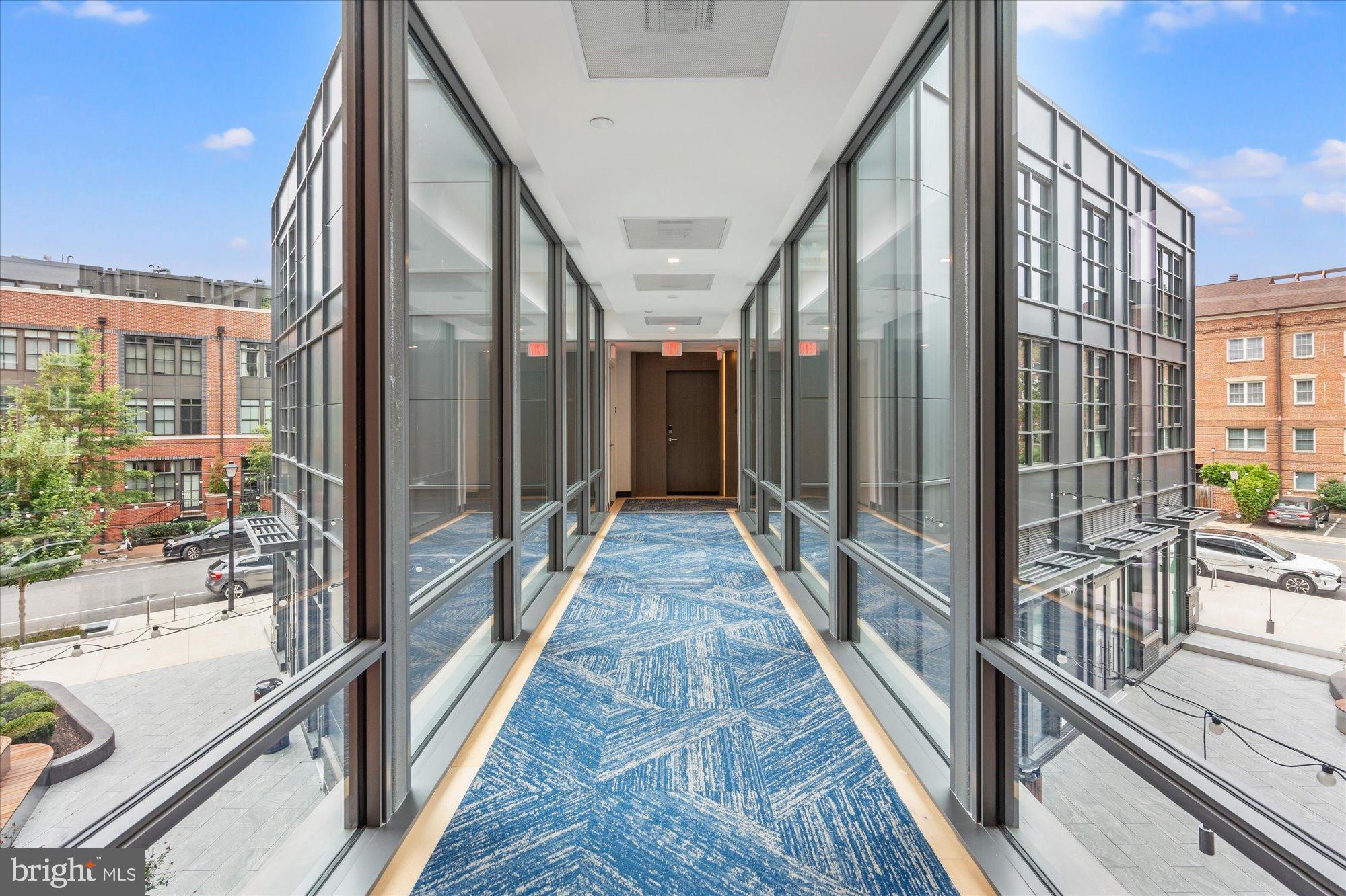 1201 North Royal Street, Unit 214 Alexandria, VA 22314 - Photo 2 of 71 Modern corridor with expansive glass views.