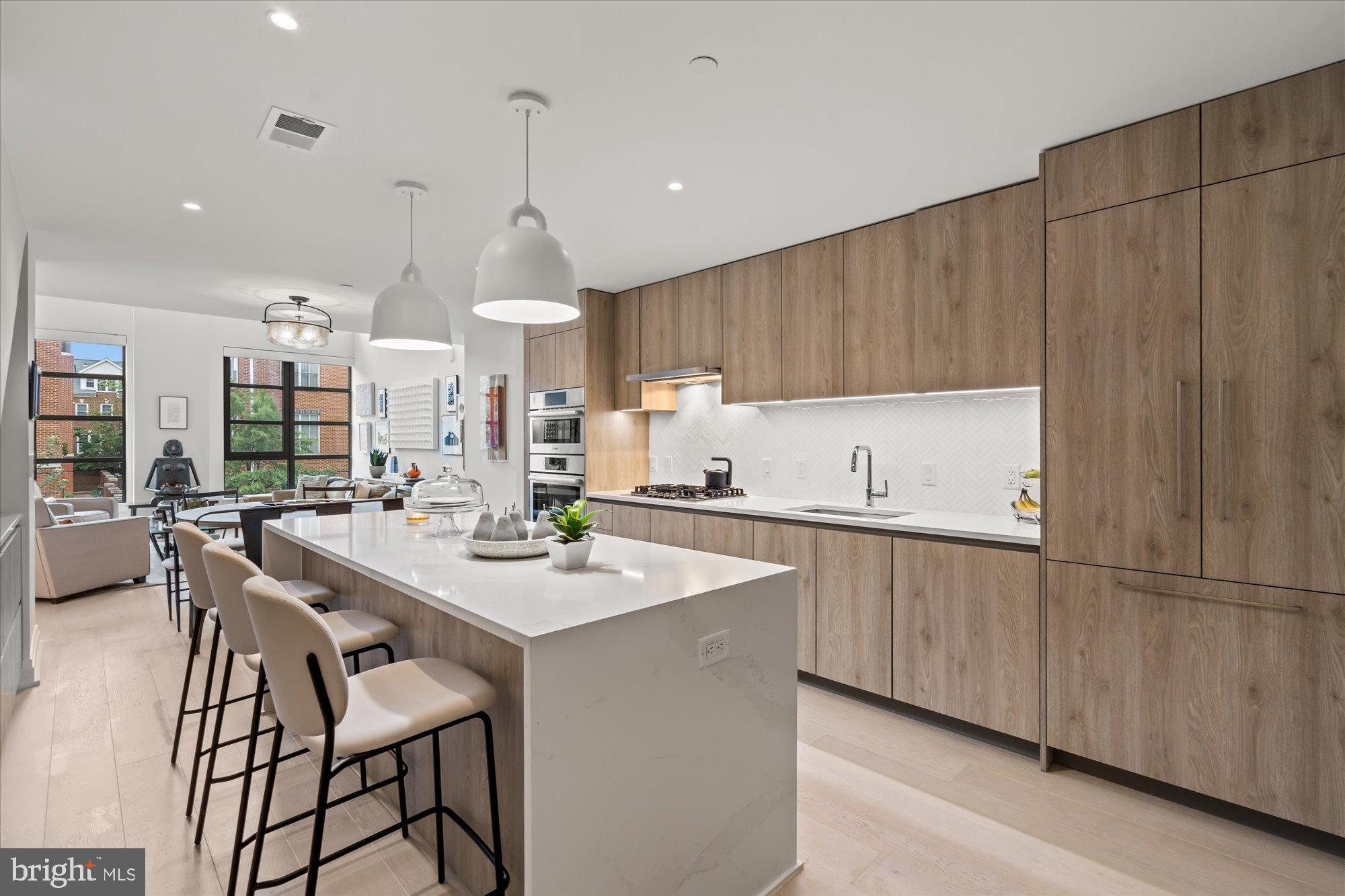 1201 North Royal Street, Unit 214 Alexandria, VA 22314 - Photo 3 of 71 a kitchen with stainless steel appliances kitchen island a table chairs sink and cabinets