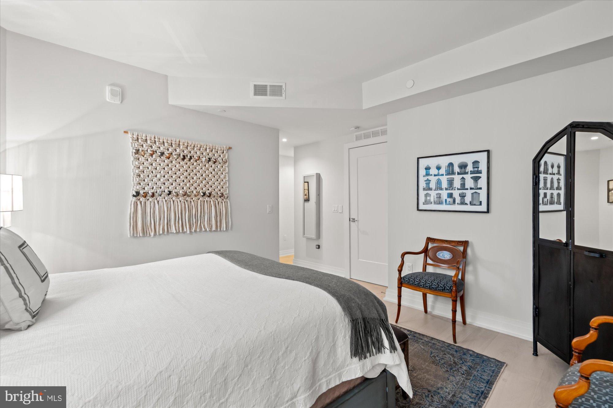 1201 North Royal Street, Unit 214 Alexandria, VA 22314 - Photo 32 of 71 a bedroom with a bed and a dresser with rug