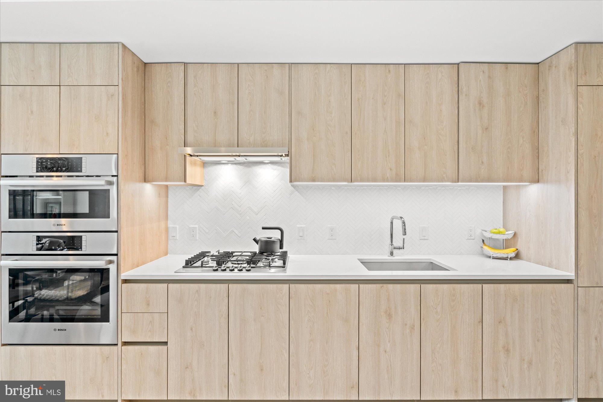 1201 North Royal Street, Unit 214 Alexandria, VA 22314 - Photo 6 of 71 a kitchen with stainless steel appliances granite countertop white cabinets and a stove top oven