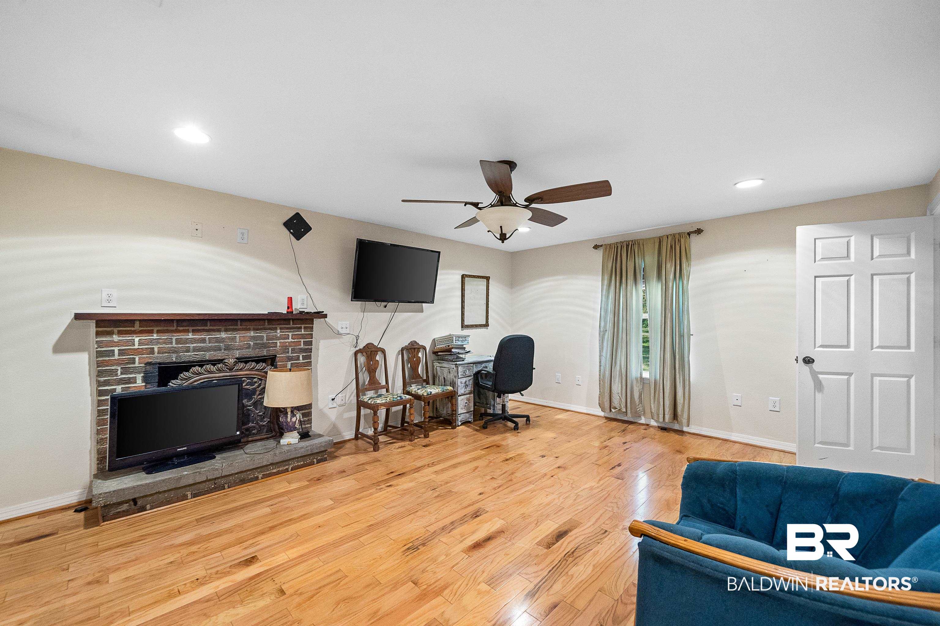 11528 Whitehouse Fork Road Bay Minette, AL 36507 - Photo 16 of 37 Living area with wood finished floors, recessed lighting, a fireplace, ceiling fan, and a desk