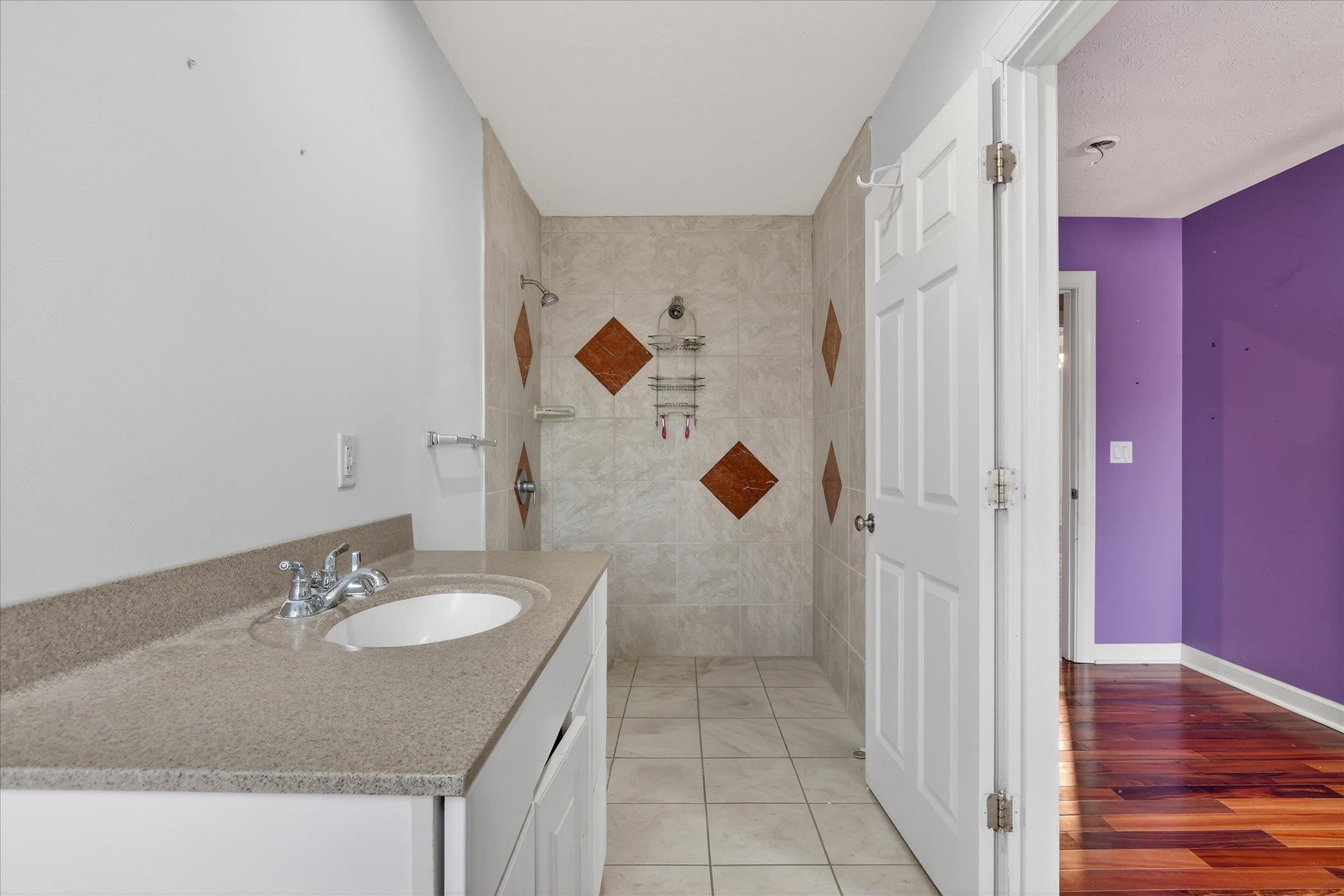 8306 East Crockett Road Roscoe, IL 61073 - Photo 13 of 61 a bathroom with a granite countertop sink a mirror and shower