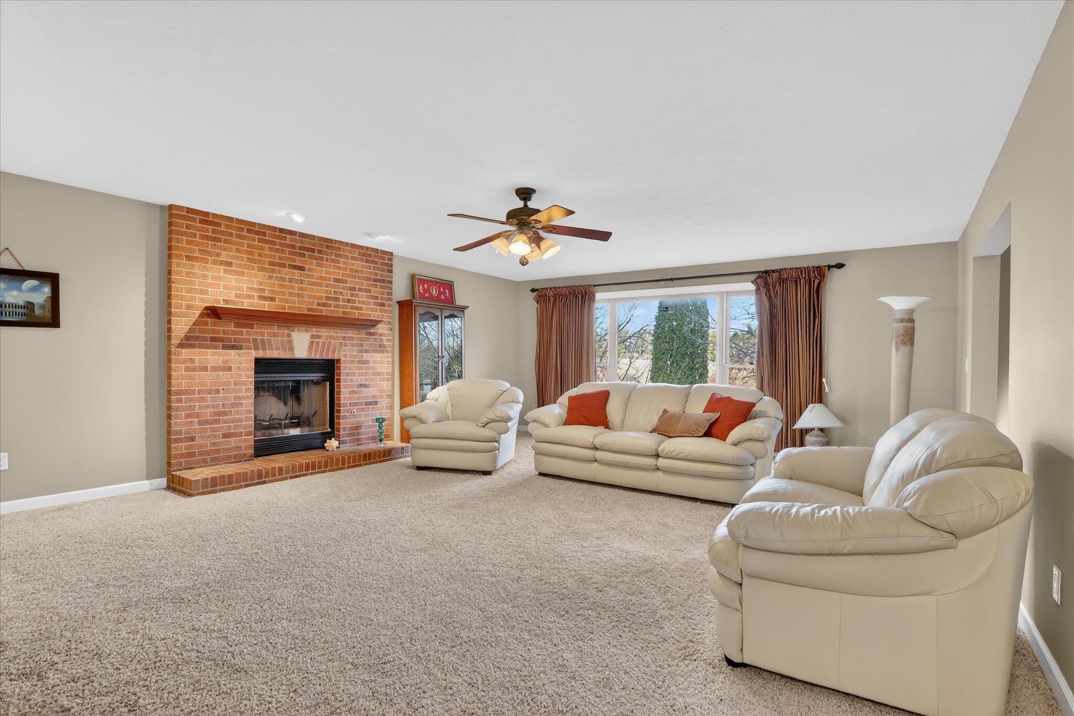 8306 East Crockett Road Roscoe, IL 61073 - Photo 28 of 61 a living room with furniture and a fireplace