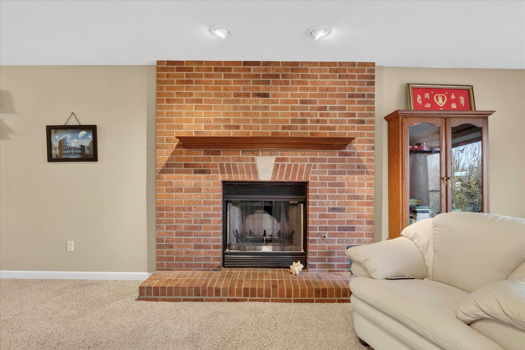 8306 East Crockett Road Roscoe, IL 61073 - Photo 36 of 61 a living room with furniture and a fireplace