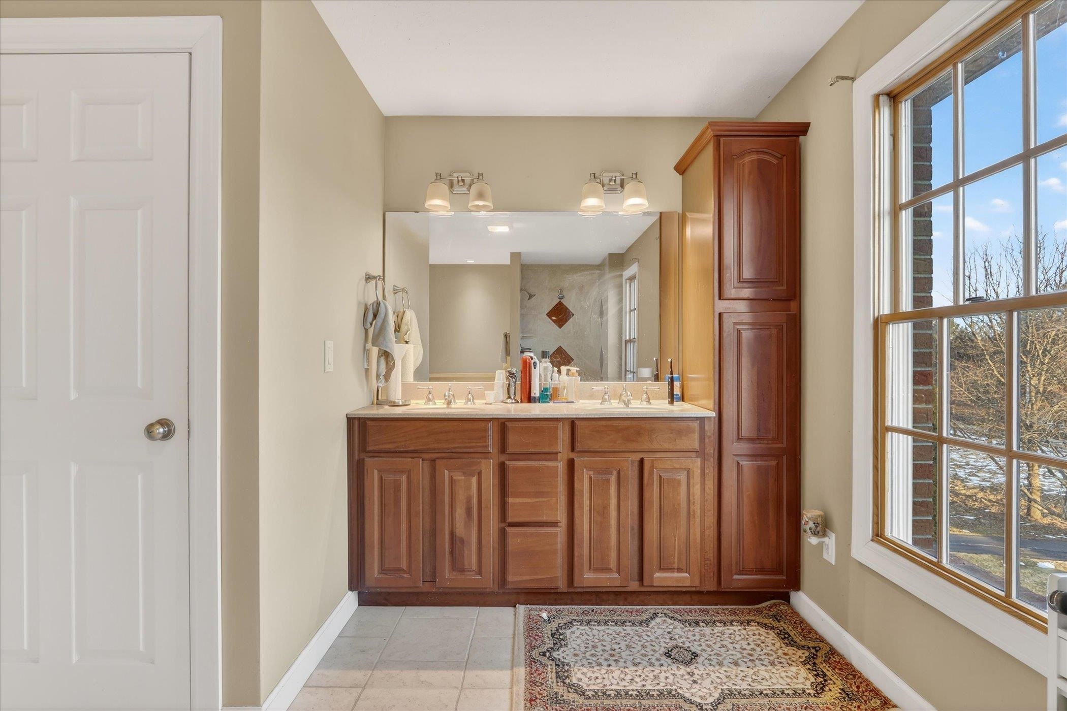 8306 East Crockett Road Roscoe, IL 61073 - Photo 50 of 61 a spacious bathroom with a double vanity sink and a mirror
