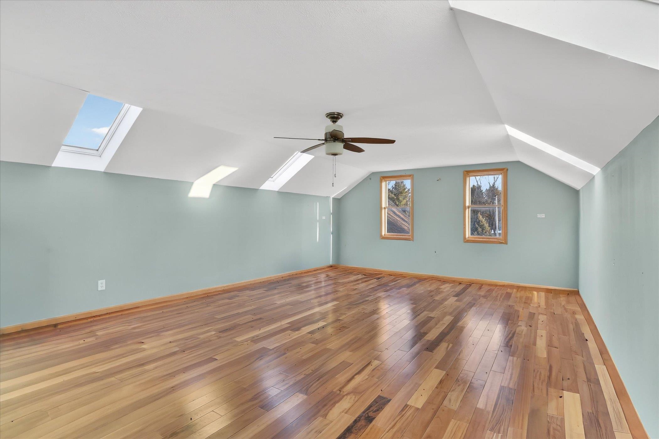 8306 East Crockett Road Roscoe, IL 61073 - Photo 52 of 61 a view of a room with wooden floor ceiling fan and a ceiling fan
