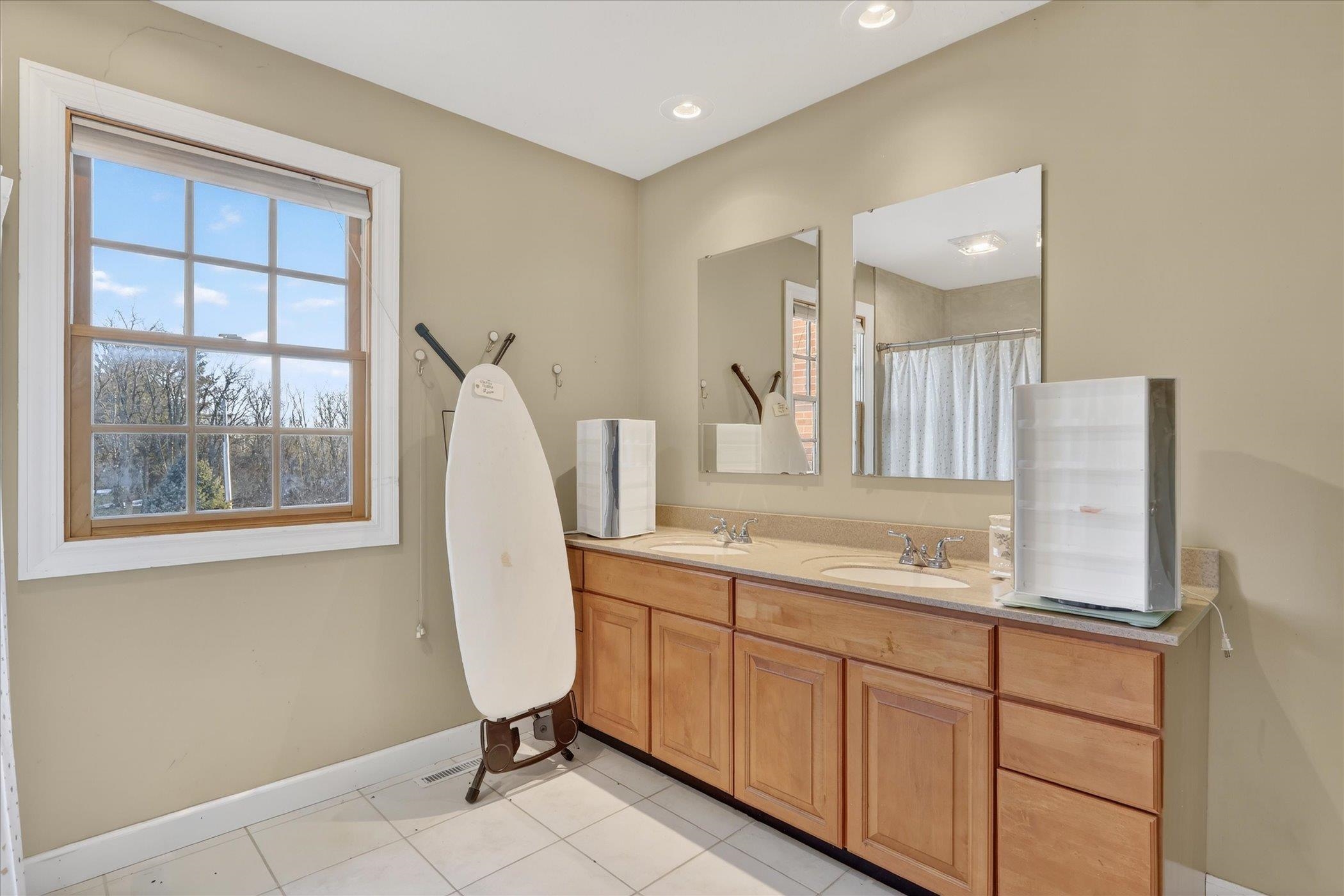 8306 East Crockett Road Roscoe, IL 61073 - Photo 9 of 61 a bathroom with a sink a mirror and a window