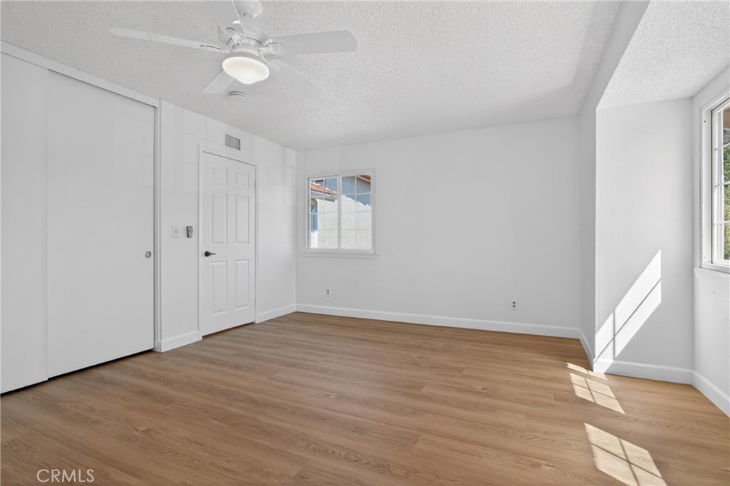 12231 Eagle Ridge Way Porter Ranch, CA 91326 - Photo 31 of 65 an empty room with wooden floor fan and windows