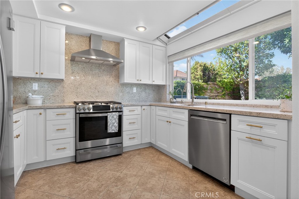 12231 Eagle Ridge Way Porter Ranch, CA 91326 - Photo 5 of 65 a kitchen with granite countertop white cabinets and white appliances
