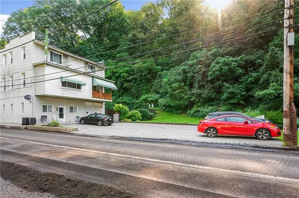 a yellow and red sign sitting on the side of a road