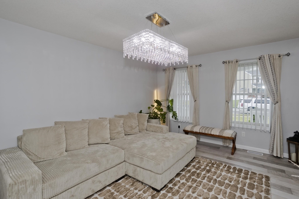 210 Naismith Street Springfield, MA 01104 - Photo 19 of 42 a living room with furniture and a chandelier