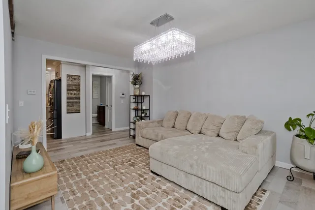 a living room with furniture and a chandelier