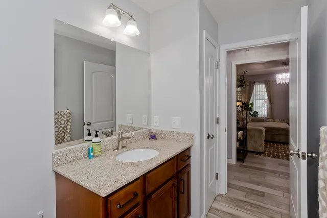 a en suite bathroom with a granite countertop sink and a mirror