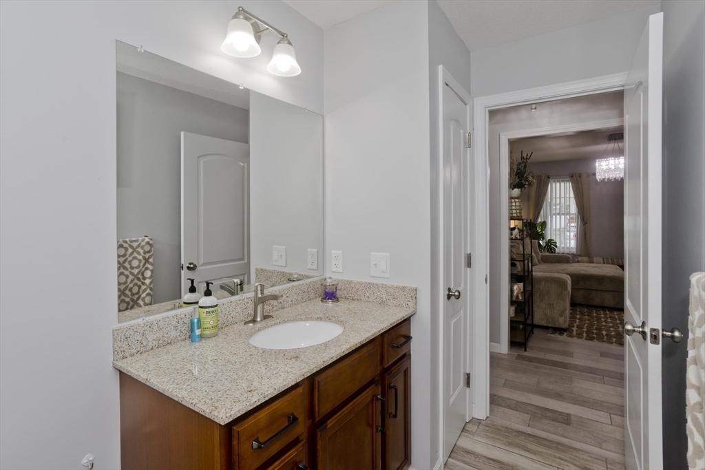 210 Naismith Street Springfield, MA 01104 - Photo 23 of 42 a en suite bathroom with a granite countertop sink and a mirror