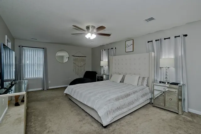 a bedroom with a large bed and a chandelier