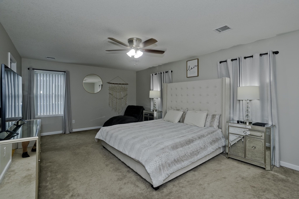 210 Naismith Street Springfield, MA 01104 - Photo 24 of 42 a bedroom with a large bed and a chandelier