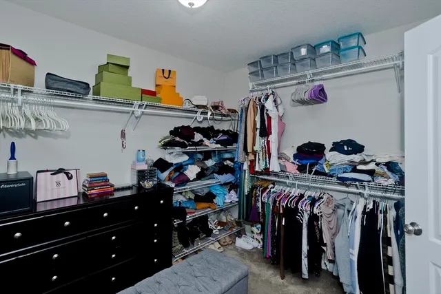 a view of walk in closet with clothes and shoes
