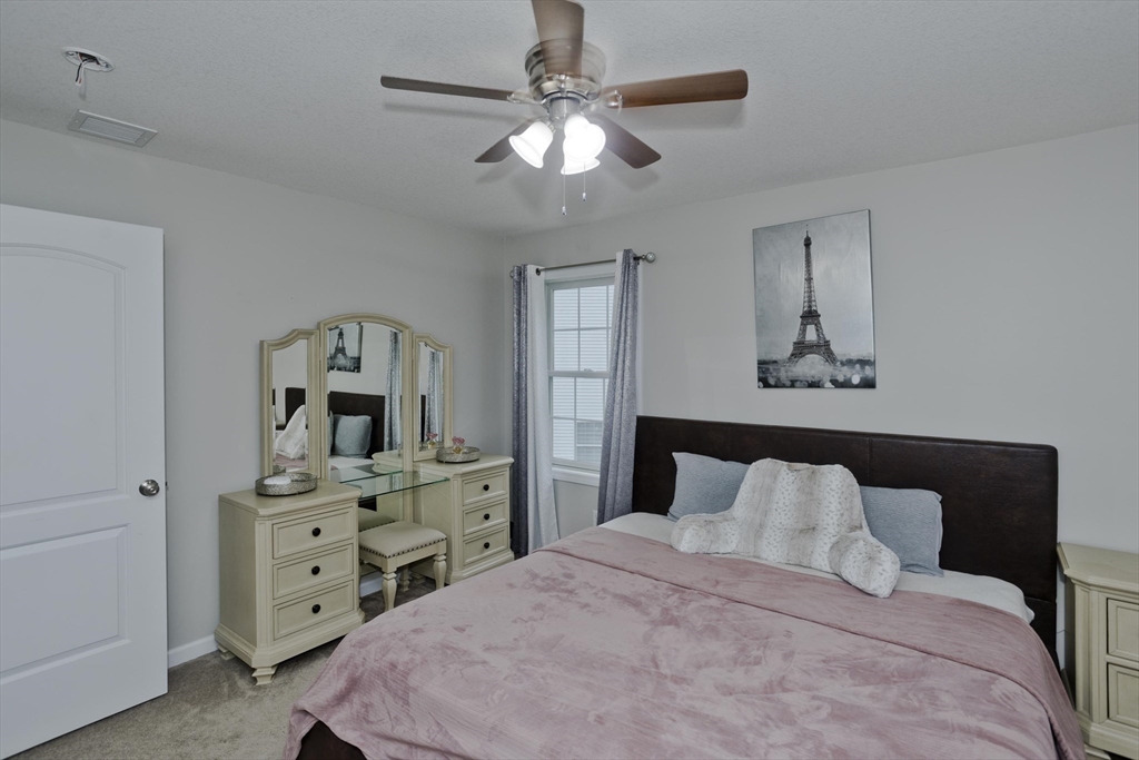 210 Naismith Street Springfield, MA 01104 - Photo 31 of 42 a bedroom with a bed and a chandelier