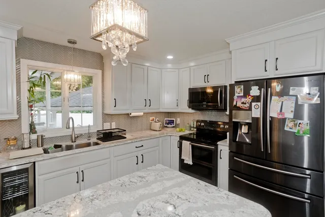a kitchen with a sink stainless steel appliances and window