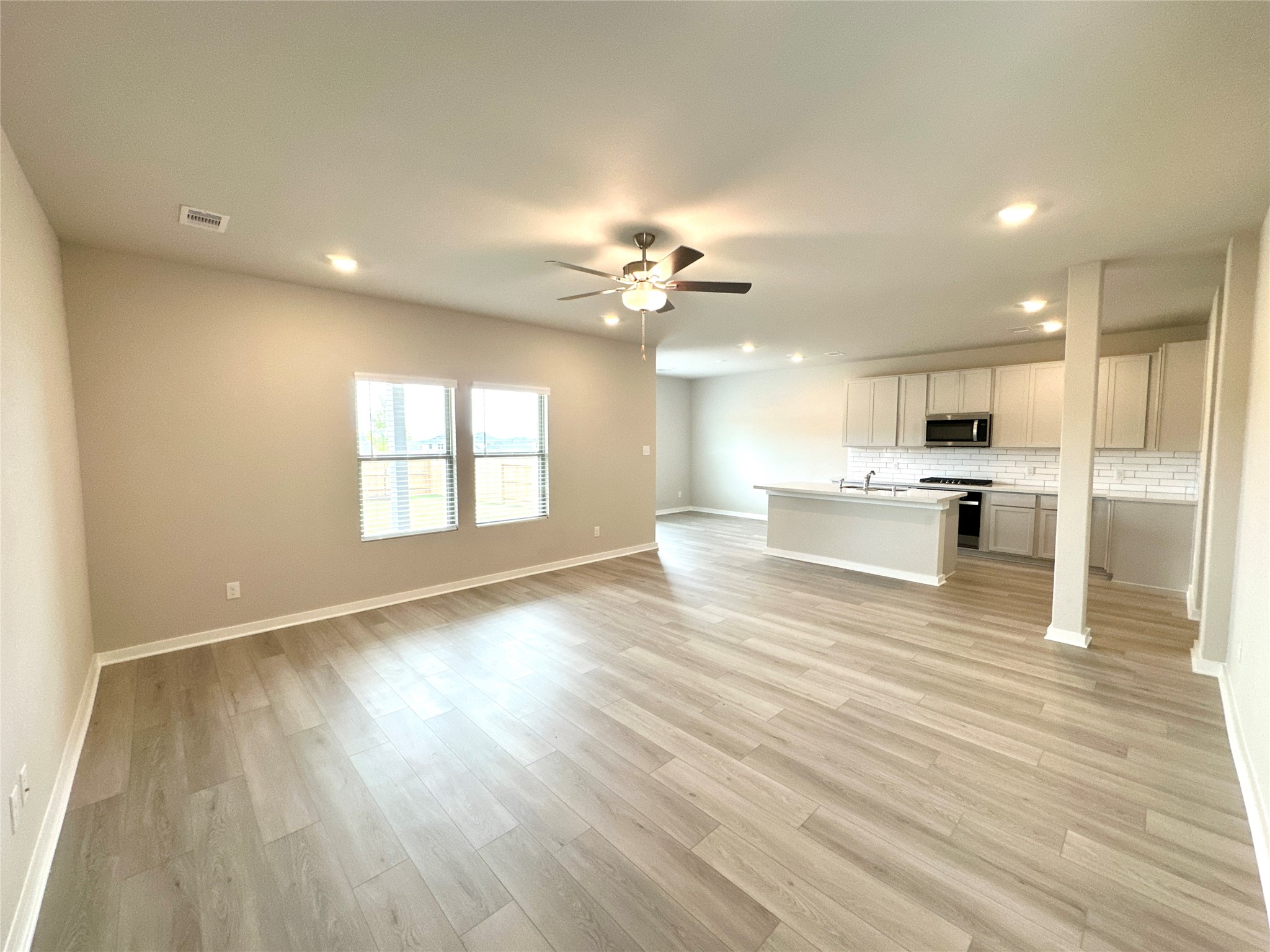 12198 Ridge Top Drive Conroe, TX 77304 - Photo 27 of 27 a view of an empty room with wooden floor and a kitchen