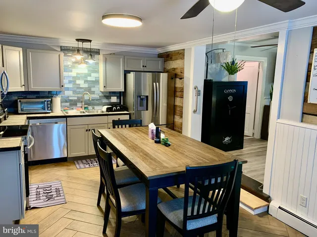 a kitchen with stainless steel appliances granite countertop a kitchen island a table and chairs in it