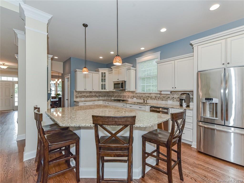 313 Olmstead Street Fort Mill, SC 29708 - Photo 12 of 48 a kitchen with stainless steel appliances granite countertop a dining table chairs refrigerator and microwave