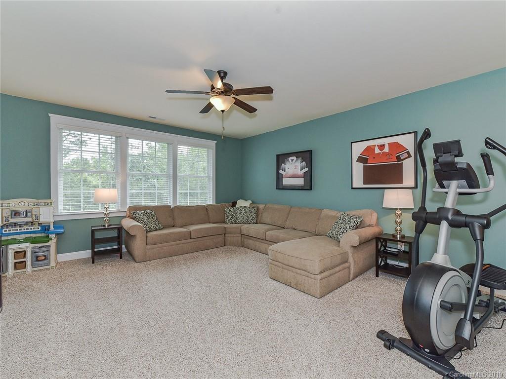 313 Olmstead Street Fort Mill, SC 29708 - Photo 25 of 48 a living room with furniture a chandelier and a flat screen tv