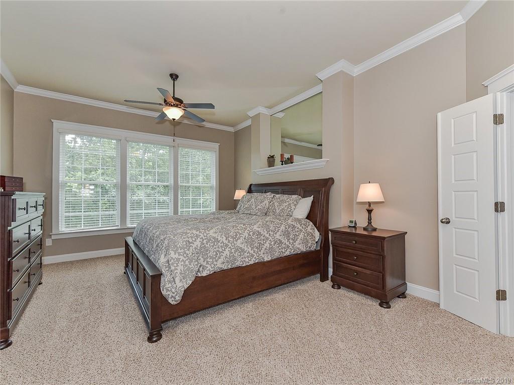 313 Olmstead Street Fort Mill, SC 29708 - Photo 27 of 48 a spacious bedroom with a bed and a chandelier