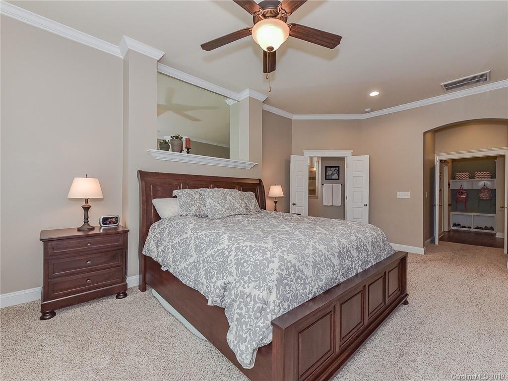 313 Olmstead Street Fort Mill, SC 29708 - Photo 28 of 48 a spacious bedroom with a bed and a chandelier