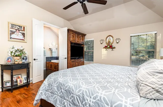 a bedroom with a bed and a dresser with wooden floor